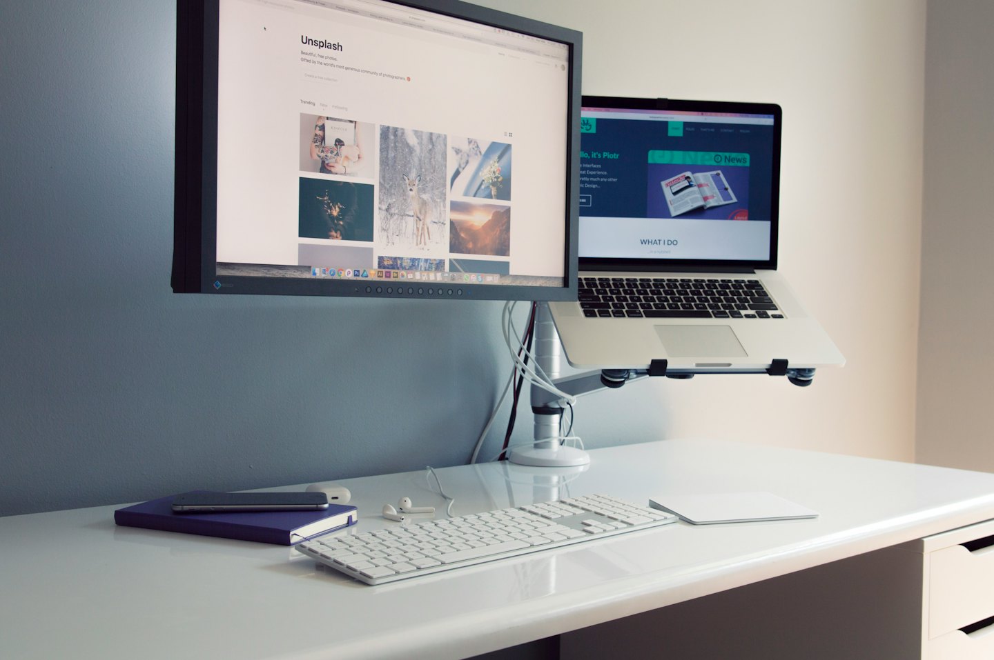 An organized desk with dual monitors and a laptop stand.